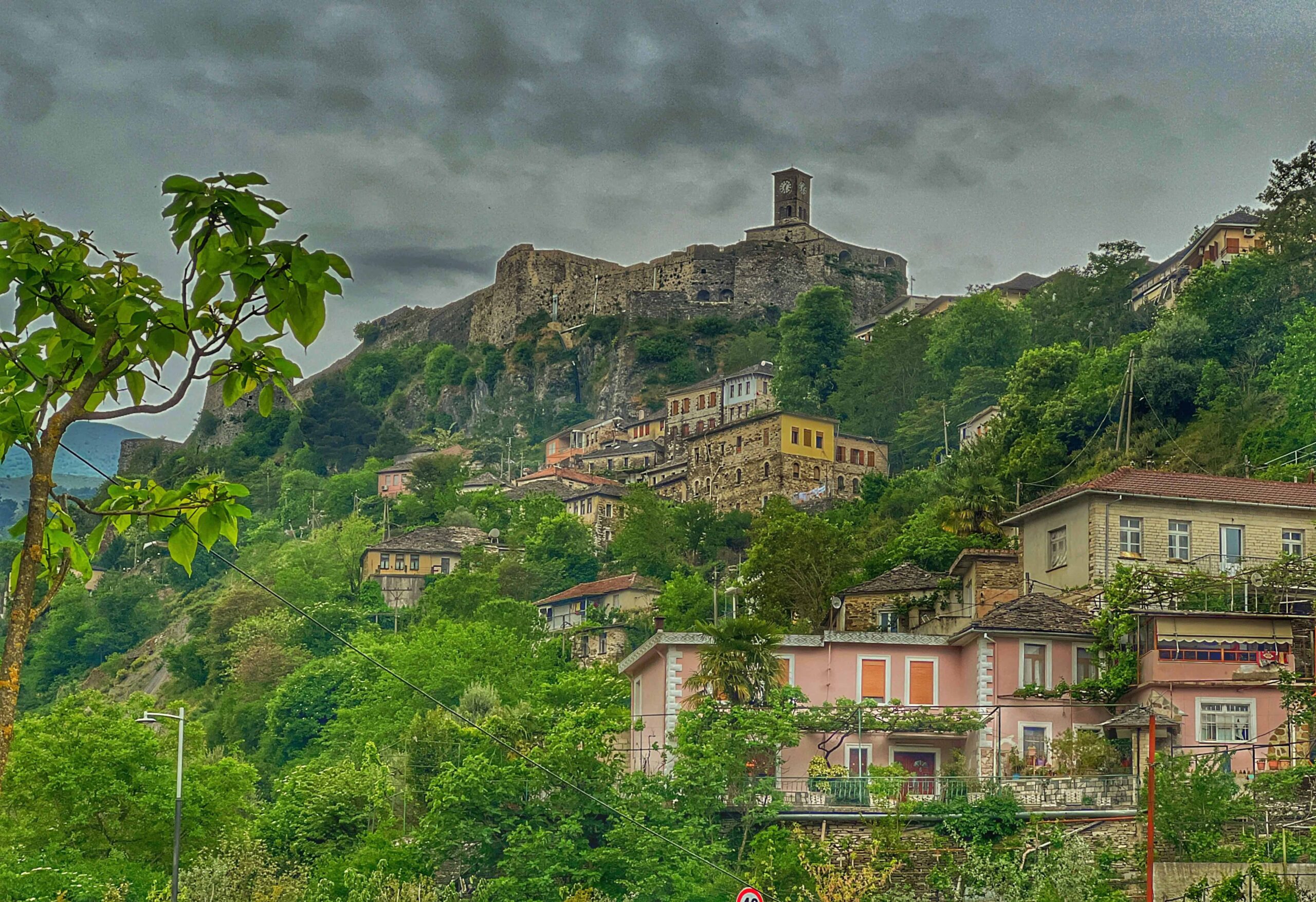 old town with stone houses and clock tower over foliage