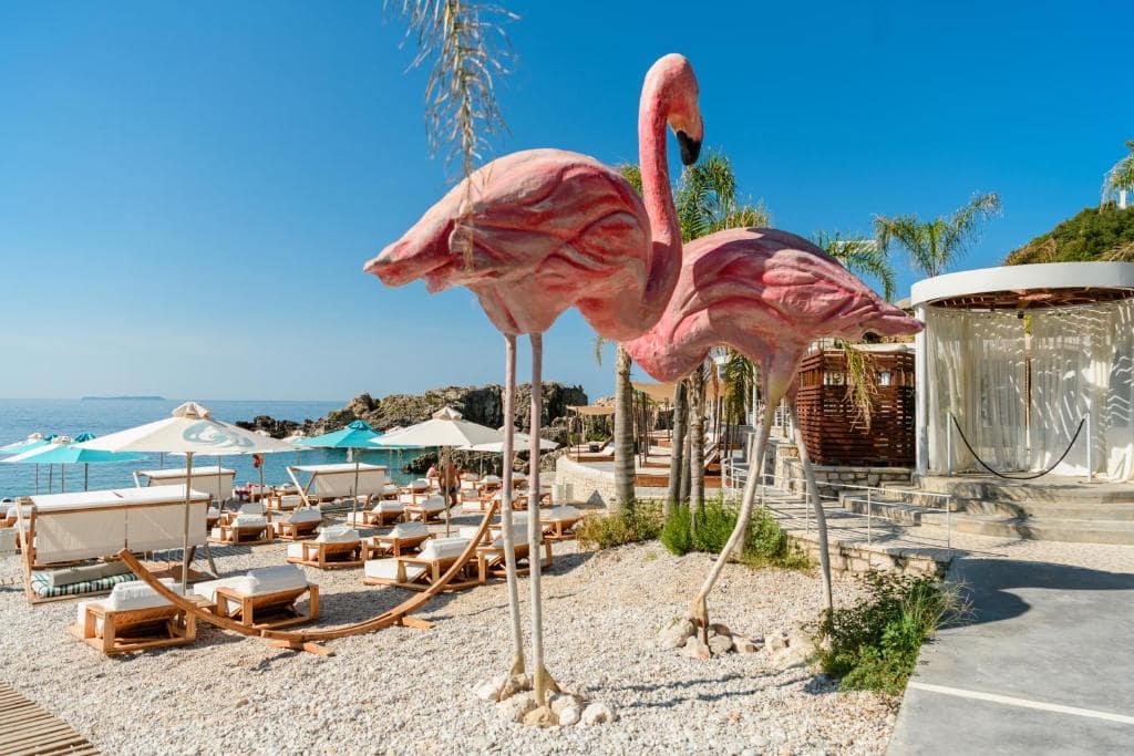 large flamingo sculptures on beach