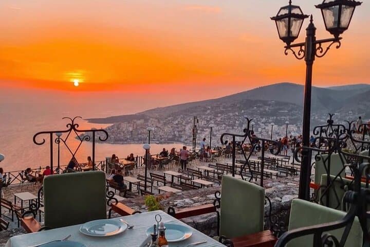 sunset view with table and city over sea