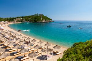 aerial shot of jale beach albania sun chairs and umbrellas on beach